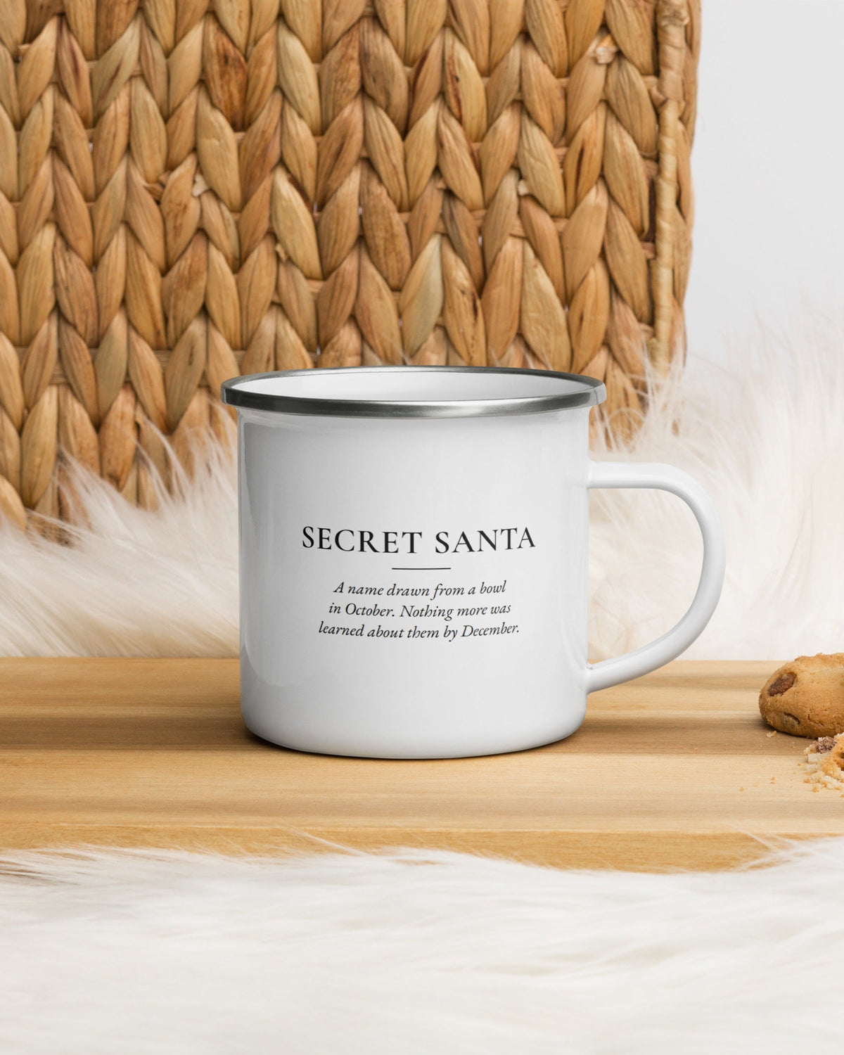 Secret Santa enamel mug on a wooden table by a jute basket