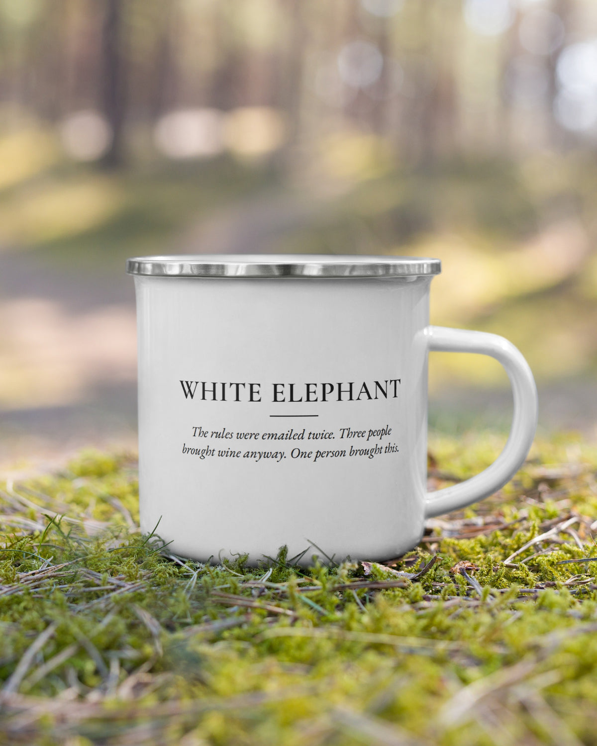 The White Elephant enamel mug on moss in a forest