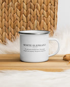 White Elephant enamel mug on a wooden table by a jute basket